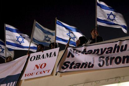 Simpatizantes del primer ministro, Benjamín Netanyahu, ondean ayer en Jerusalén banderas israelíes y carteles de apoyo al jefe del Ecutivo en los que puede leerse: "Obama, tú no puedes" o "Netanyahu, mantente firme".