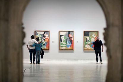 Una de las salas del Museo Picasso de Barcelona con tres visitantes.