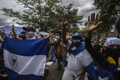 Un grupo de amigos y familiares rezan a la entrada de El Chipote, el centro donde son trasladados los detenidos durante las protestas.