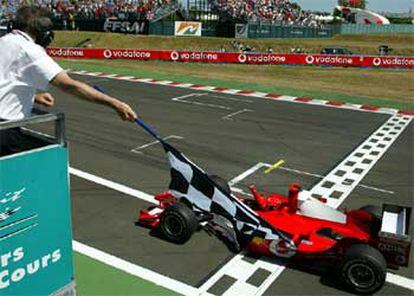 Michael Schumacher levanta el puño en señal de victoria al atravesar la meta del circuito de Magny Cours.
