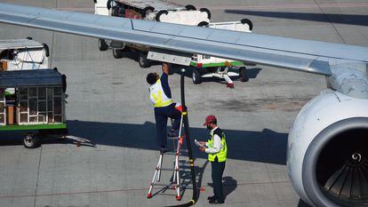 Operarios cargan combustible en un avión comercial.