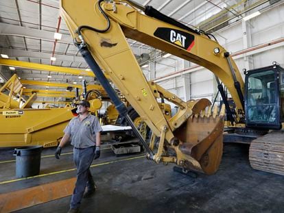 Un empleado de una empresa de maquinaria industrial pasa ante una excavadora en Flowood (Misisipi), en septiembre de 2019.