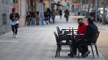 Dos personas en la terraza de un bar de Carabanchel (Madrid).
