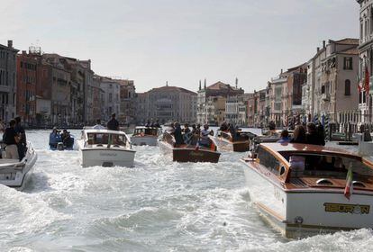 El bote 'Amore', en el que viajan George Clooney y su prometida, Amal Alamuddin, navega en el Gran Canal seguido por varios paparazis en 'vaporettos'.