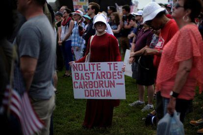 Una mujer vestida como las protagonistas de la serie 'El Cuento de la Criada' sostiene un letrero en latín durante una manifestación bajo el lema Marcha por la Verdad exigiendo una investigación imparcial sobre la interferencia rusa en las elecciones presidenciales de 2016 en Estados unidos, en junio de 2017.