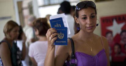 Una mujer muestra su pasaporte al salir de una oficina de inmigraci&oacute;n en La Habana. 