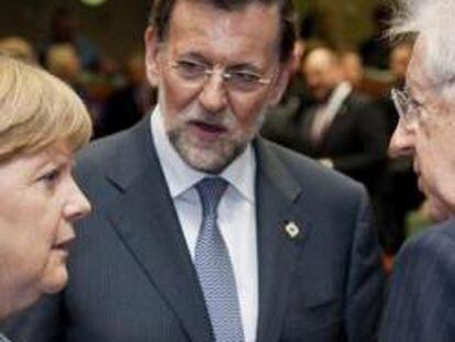 La canciller alemana, Angela Merkel, el presidente del Gobierno español, Mariano Rajoy (c), y el primer ministro italiano, Mario Monti (d), charlan al comienzo de la cumbre informal de jefes de Estado y Gobierno en Bruselas el 23 de mayo de 2012.