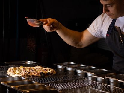 El cocinero Andrés Felipe López Londoño da el último toque a una de las pizzas de Humo Pizza, en San Sebastián.
