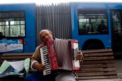 Coincidencias Urbanas. Un hombre tocando el acordeón en la calle, justo cuando pasa un autobús por detrás, en Madrid, en abril de 2010.