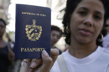 Una mujer muestra su pasaporte en una cola frente a una oficina en La Habana, el viernes.