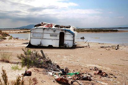 Una caravana abandonada y otros desperdicios esparcidos cerca de la playa de la Punta del Fangar.