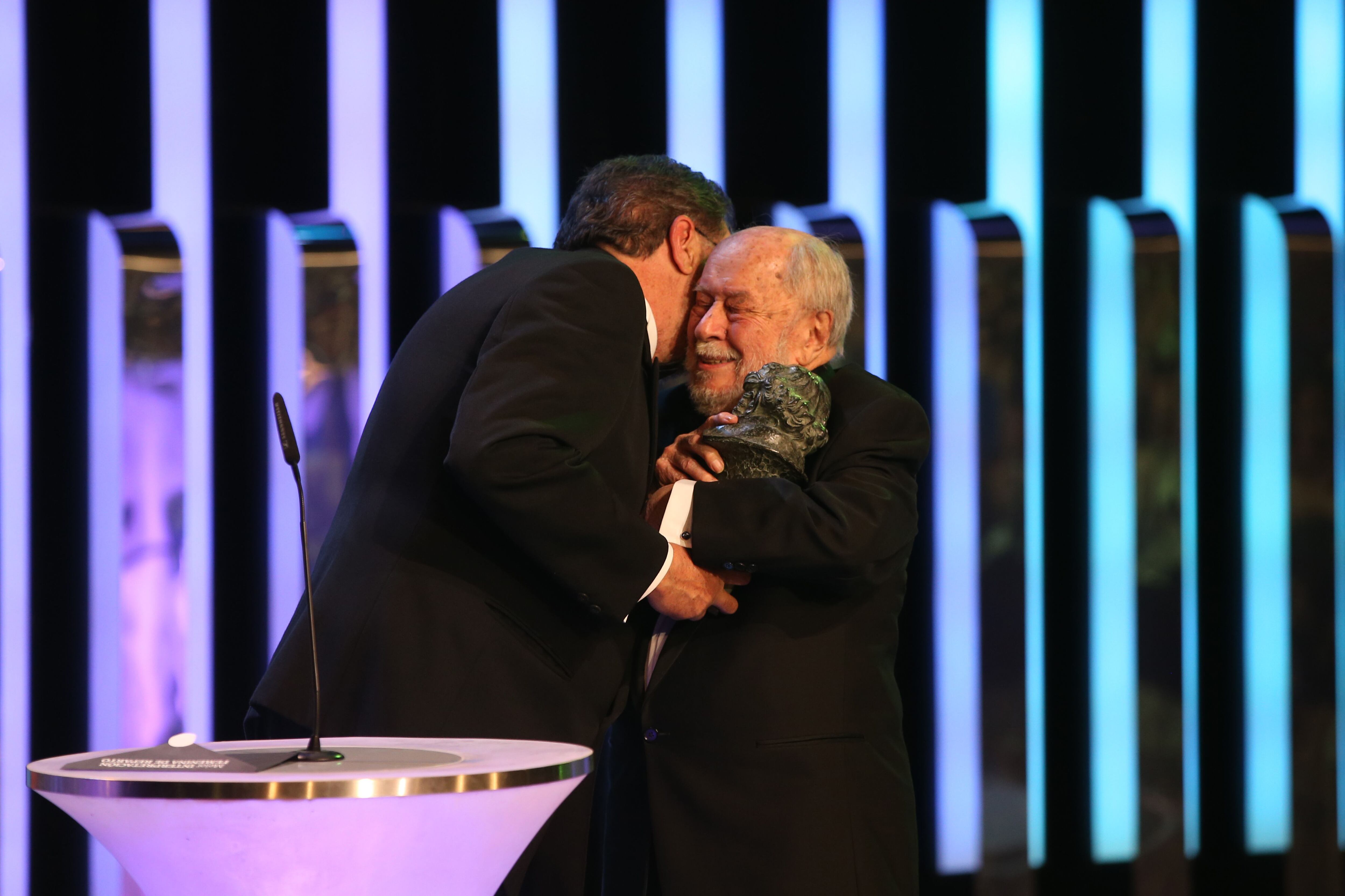 Jaime de Armiñán, premio de honor en los Goya 2014, es abrazado por el presidente de la Academia, Enrique González Macho.
