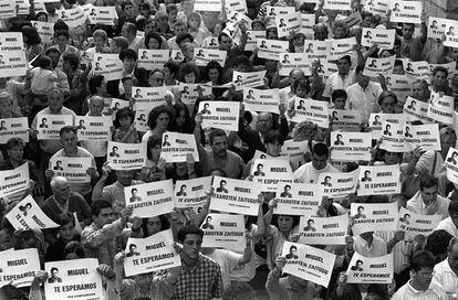 Miles de vecinos de Ermua (Bizkaia) salieron a las calles el 11 de julio para pedir la liberación de Miguel Ángel Blanco, concejal del PP, secuestrado el día anterior. En los carteles se lee: "Miguel te esperamos", en castellano y euskera.