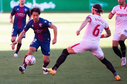 Okaza, del Huesca, y Gudelj, en una acción del partido.