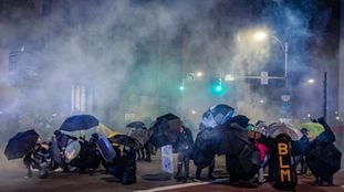 Protesters use umbrellas and homemade shields in an attempt to protect themselves from pepper,"less-lethal" munitions and teargas in Rochester, New York, on September 5, 2020, on the fourth night of protest following the release of video showing the death of Daniel Prude. - Prude, a 41-year-old African American who had mental health issues, died of asphyxiation after police arrested him on March 23, 2020, in Rochester. (Photo by Maranie R. STAAB / AFP)