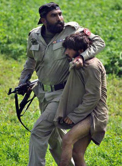 Un paramilitar detiene a uno de los asaltantes en Lahore.