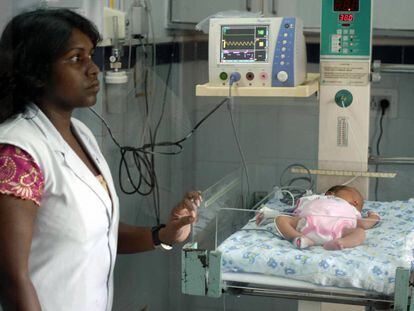 Una enfermera india con un bébé nacido a través de la maternidad subrogada en un hospital de Jaipur, este agosto.