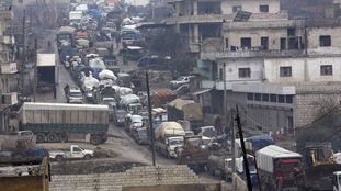 Una caravana de coches huye este jueves hacia la frontera turca ante el avance gubernamental en Idlib.