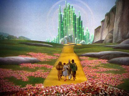 Un fotograma de 'El mago de Oz', con la Ciudad de Esmeralda y Dorothy y sus amigos en el camino de baldosas amarillas.