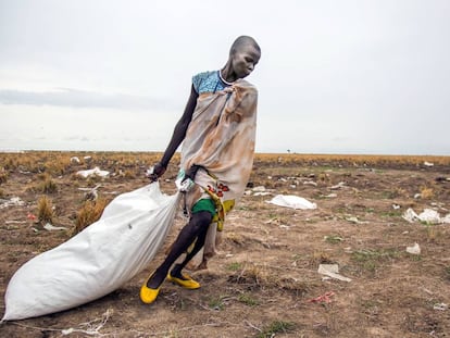 Una mujer arrastra un saco de comida lanzado desde el aire por el Programa Mundial de Alimentos en Ganyiel (Sudán del Sur).