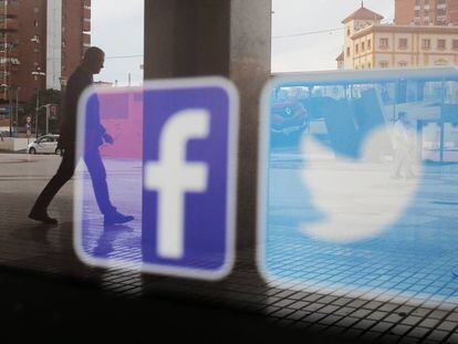 Los logos de las redes sociales Facebook y Twitter aparecen en el escaparate de una tienda en Málaga.