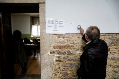 Un hombre acercaba una lupa pare leer los carteles este domingo en el IES Rosalía de Castro, en Santiago.