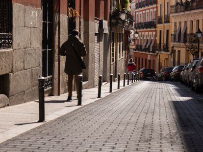 Un vecino camina por la calle de Lavapiés, en Madrid y recién cubierta con asfalto impreso, el 2 de marzo de 2022.
