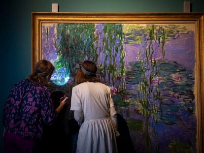 La comisaria Aurélie Gavoille y la restauradora Mónica Ruiz Trilleros revisan una obra de la serie 'Nenúfares' de Monet a su llegada a CentroCentro.