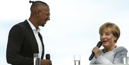 La canciller Angela Merkel habla con el futbolista Jerome Boateng el pasado 28 de agosto durante la jornada de puertas abiertas de la Cancillería en Berlín.