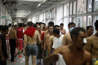 Alguns dels ciutadans evacuats fan cua per rebre roba donada al refugi temporal obert en una escola a Tianjin.