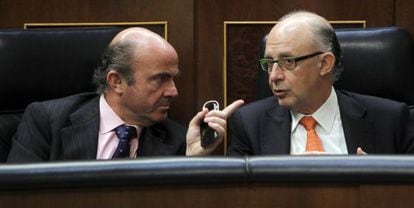 El ministro de Econom&iacute;a, Luis de Guindos, conversa con el ministro de Hacienda, Crist&oacute;bal Montoro, en el Congreso.