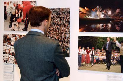 Una persona observa varias fotografias que componen la exposición "Efe, 75 años en fotos.