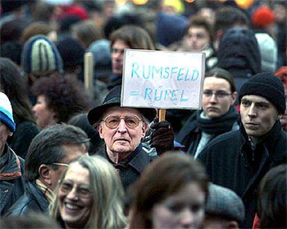 Un manifestante muestra un cartel en el que se lee "Rumsfeld = palurdo", ayer en Múnich.