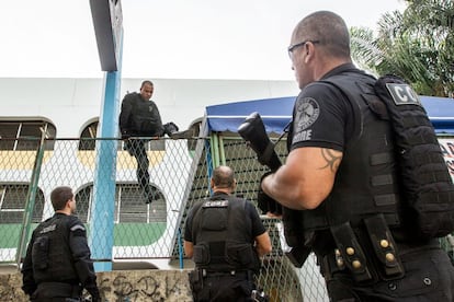 Policías de la CORE (Coordinadora de Recursos Especiales de la Policía Civil) saltan cerca de una escuela del Complexo da Maré, en Río de Janeiro, en busca de criminales.