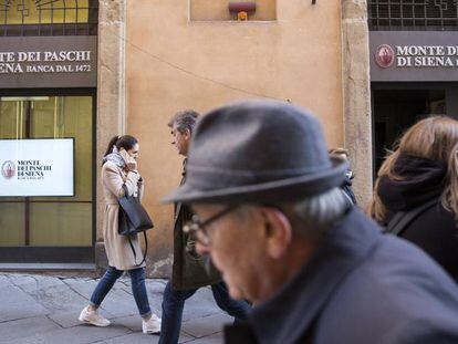 Viandantes, ante una oficina del banco Monte dei Paschi de Siena.