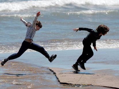 Dos niños juegan en la playa de la Malvarrosa de Valencia. En vídeo, el buen tiempo en algunas zonas costeras.