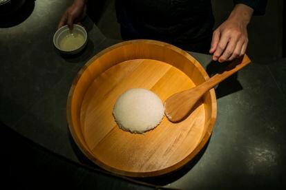  Tadayoshi Motoa mezcla el arroz con el vinagre en un hangiri (palangana de madera).