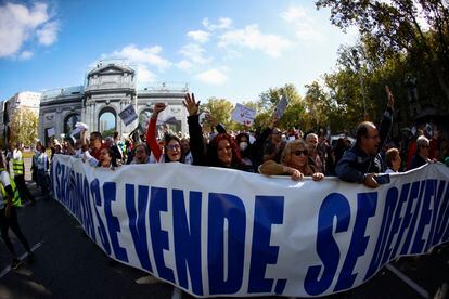 Centenares de personas a su pasa por la Puerta de Alcalá, este domingo. 