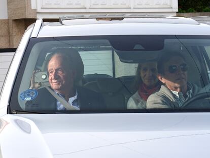 El rey Juan Carlos I (a la izquierda) saluda a su llegada a la vivienda de su anfitrión, Pedro Campos (a la derecha, al volante) en Sanxenxo (Pontevedra), este jueves. En el asiento de atrás, a la derecha, la infanta Elena.