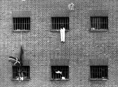 Los reclusos se asoman a las ventanas de la cárcel de Carabanchel (Madrid) el 15 de marzo de 1990 durante los incidentes producidos durante la huelga de 24 horas de funcionarios de prisiones en protesta por el asesinato por ETA de su comapero Ángel Mota.