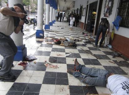 Un fotógrafo toma la imagen de una de las cinco personas asesinadas en Los Reyes.