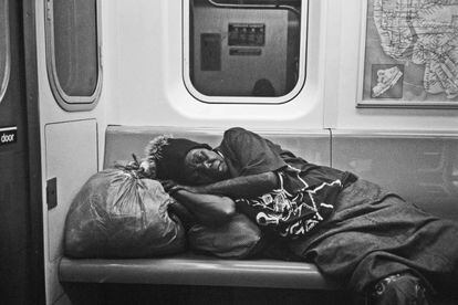Una persona duerme en el metro de Nueva York.