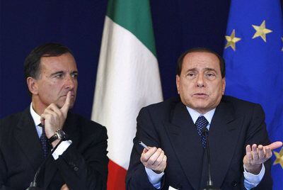 Franco Frattini escucha a Berlusconi en rueda de prensa.