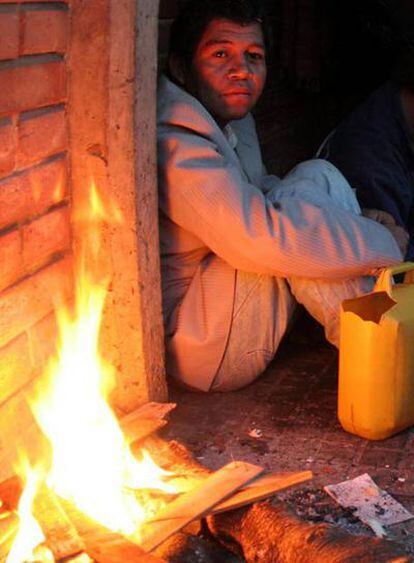 Un indígena paraguayo se refugia del frío en una plaza de Asunción.