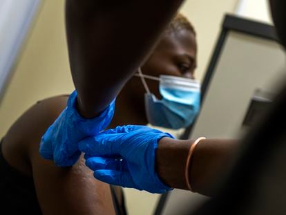 Un sanitario vacuna contra la covid a un ciudadano en una hospital a las afueras de Johannesburgo.