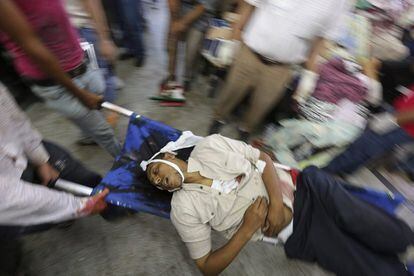  Activistas de los Hermanos Musulmanes evacúan el cadáver de un simpatizante del depuesto presidente egipcio Mohamed Morsi durante un enfrentamiento entre simpatizantes del depuesto presidente y las fuerzas de seguridad en El Cairo (Egipto),  8 de julio de 2013.