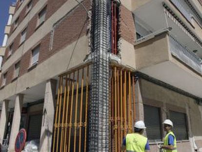 Obreros apuntalan un edificio en Lorca.