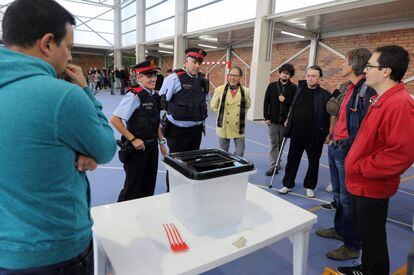 Dos mossos ante una urna de un colegio durante la jornada del referéndum del 1 de octubre en Cataluña.