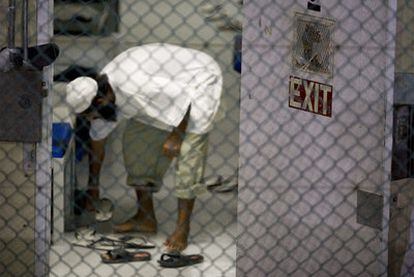 Un detenido se calza para ir al rezo matutino en su celda de la prisión de Guantánamo, en noviembre de 2008.