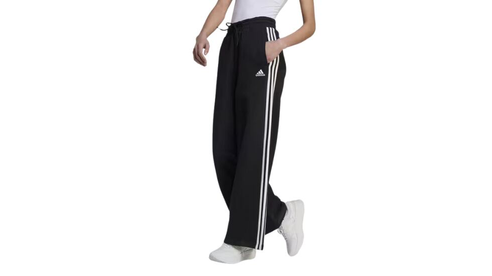 Pantalón Adidas Essentials French Terry Wide con tres bandas en los laterales y en color negro.